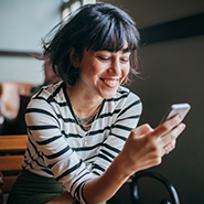 woman smiling while using her cellphone 