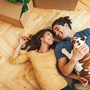 couple with a dog laying on the floor smiling
