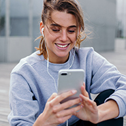 Woman with earbuds checking mobile phone