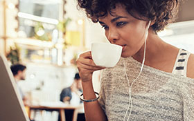 woman sipping coffee at her laptop